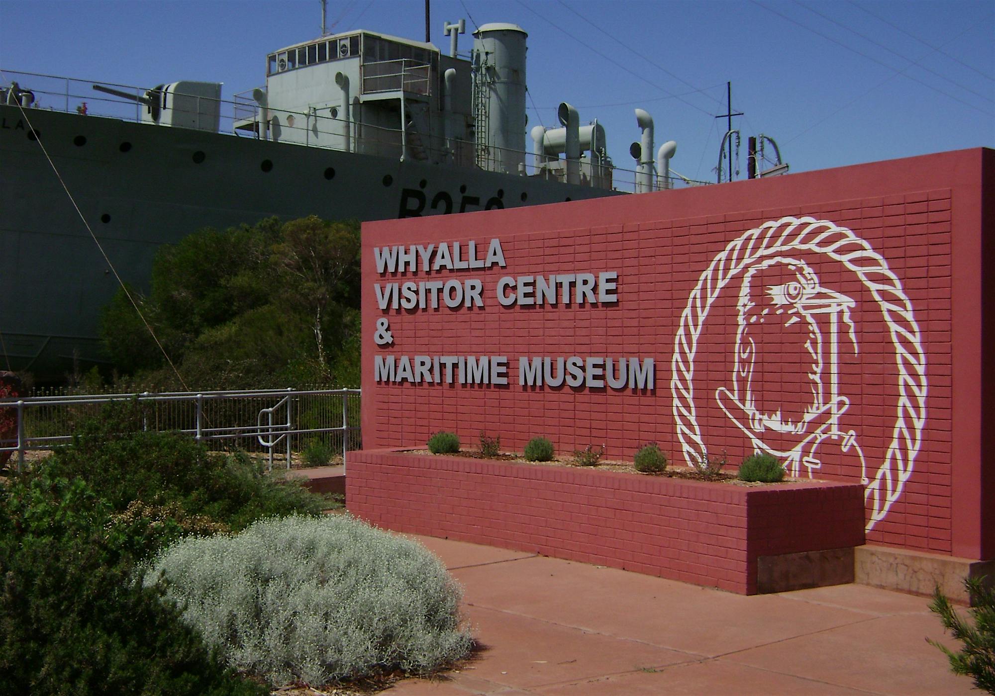 Sign in front of a museum ship reading, "WHYALLA VISITOR CENTRE & MARITIME MUSEUM"